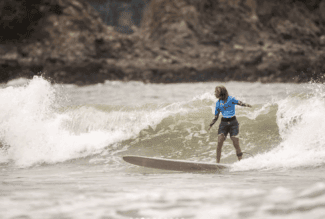 Surfista ejecutando paso clásico sobre una ola en Sayulita durante el Longboard Contest 2025.